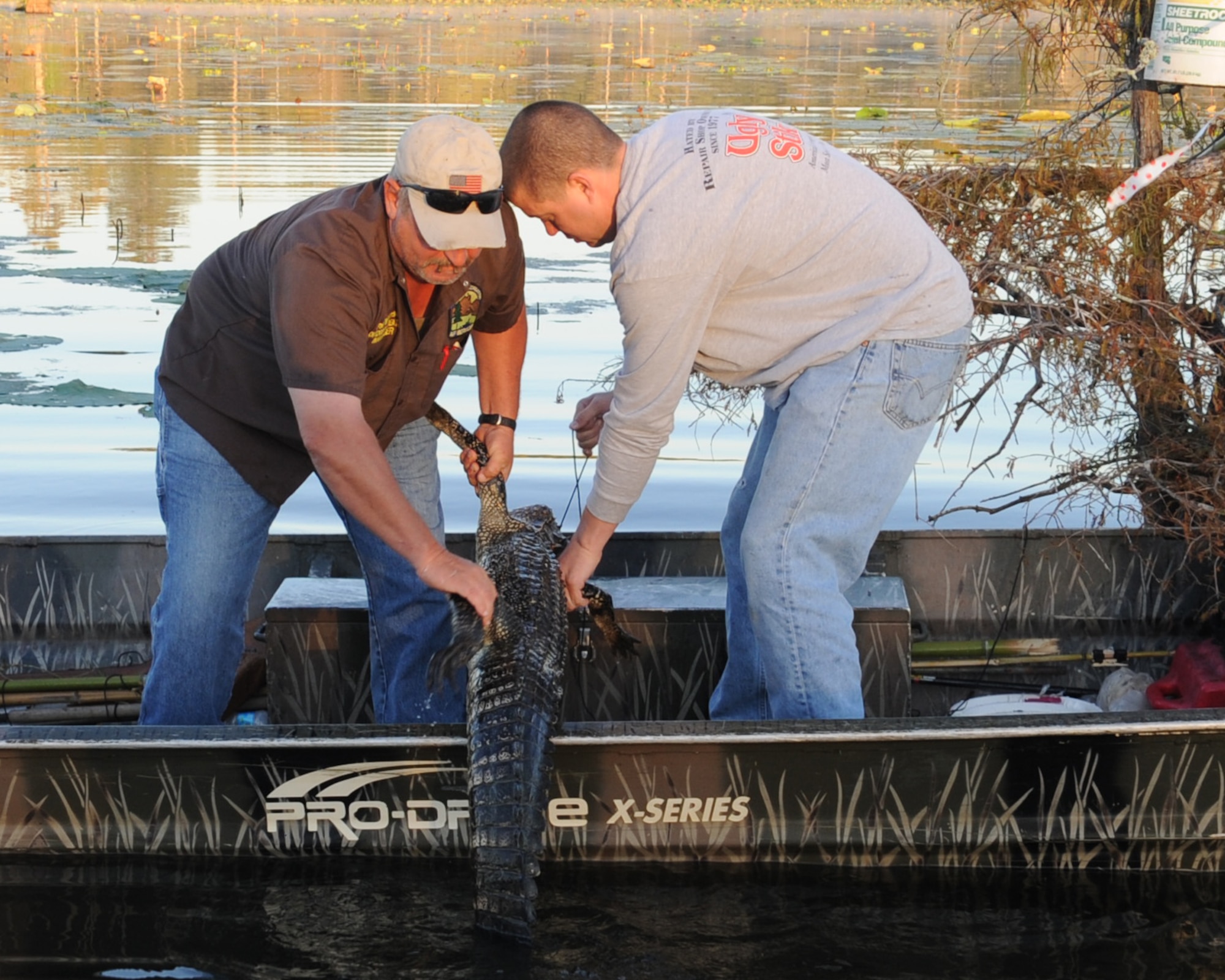 Paul Williamson (left), 2nd Force Support Squadron outdoor recreation manager, and Staff Sgt. Trevor Padgett (right), Air Force Global Strike Command safety office, pull in an alligator that was caught on Flag Lake on Barksdale Air Force Base, La., Sept. 11. The alligator hunting season for Barksdale began on Sept. 5. and runs until the Sept. 16. (U.S. Air Force photo/Senior Airman Sean Martin) (RELEASED)