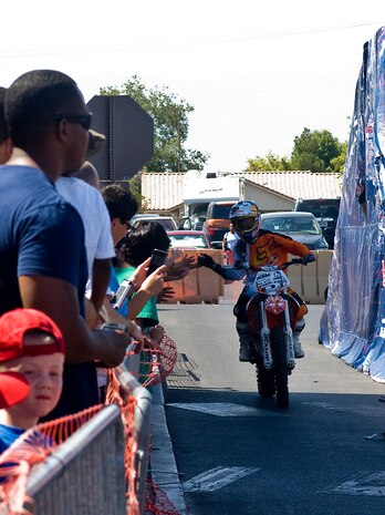 Rodney Renner, Red Bull Jams motocross rider, high-fives crowd members Sept. 8, 2012, at The Exchange here. Renner is an X-Games gold medalist.(U.S. Air Force photo by Senior Airman Jack Sanders)