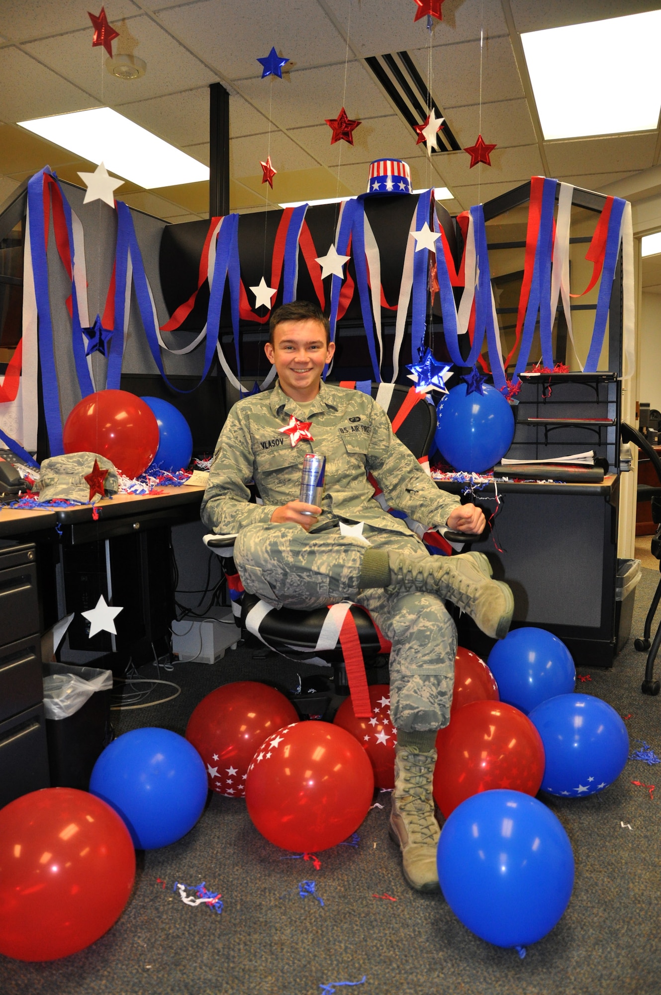 Airman 1st Class Nikolai Smirnoff smiles in delight after discovering the surprise that awaited him back at his work station Aug. 30, 2012. Smirnoff’s co-workers at the 319th Comptroller Squadron decorated the Airman’s workstation from top to bottom in a red, white and blue theme in celebration of his new U.S. citizenship.  (U.S. Air Force photo/Airman 1st Class Jeffrey Lowder)