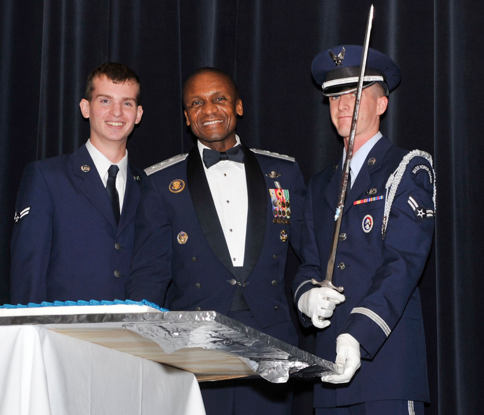 Lt. Gen. Darren McDew, commander of 18th Air Force, poses with Airman 1st Class Christopher Sims, left, the youngest Airman in attendance, and Airman 1st Class David Brannum, Team Dover honor guard member, after cutting the birthday cake at the Air Force Ball Sep. 7, 2012, at Dover Downs in Dover, Del. The cutting of the cake was part of the celebration commemorating the Air Force’s 65th birthday. (U.S. Air Force photo by Tech. Sgt. Chuck Walker)