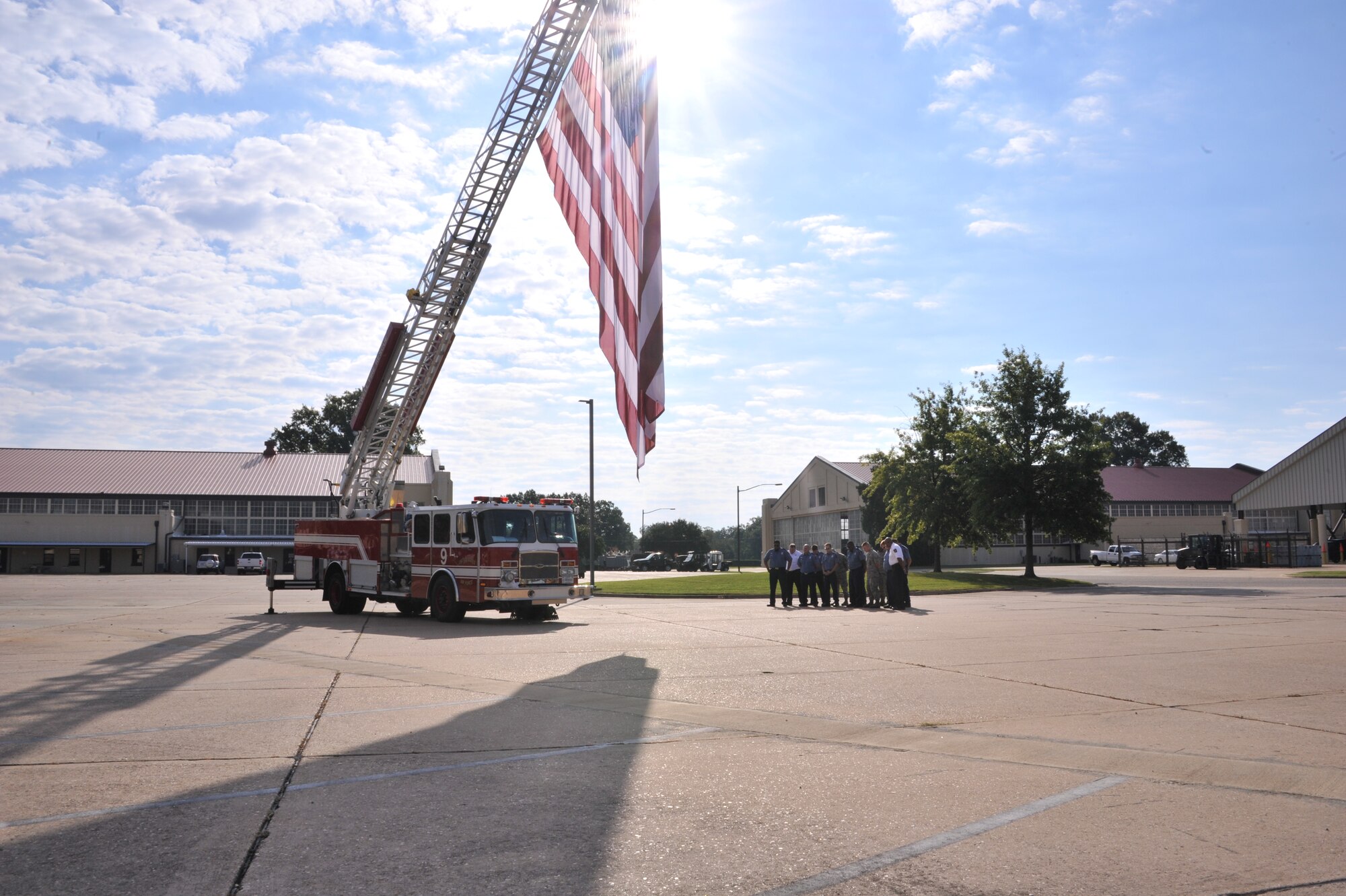 Maxwell Air Force Base Fire Department members gather around an American flag flown at half-staff to honor those to lost their lives 11 years ago, Sept. 11, 2001. Several members of the team spoke about their remembrance of the attack on America and the desire never to forget that moment in history. (U.S. Air Force photo by Airman 1st Class William Blankenship) 