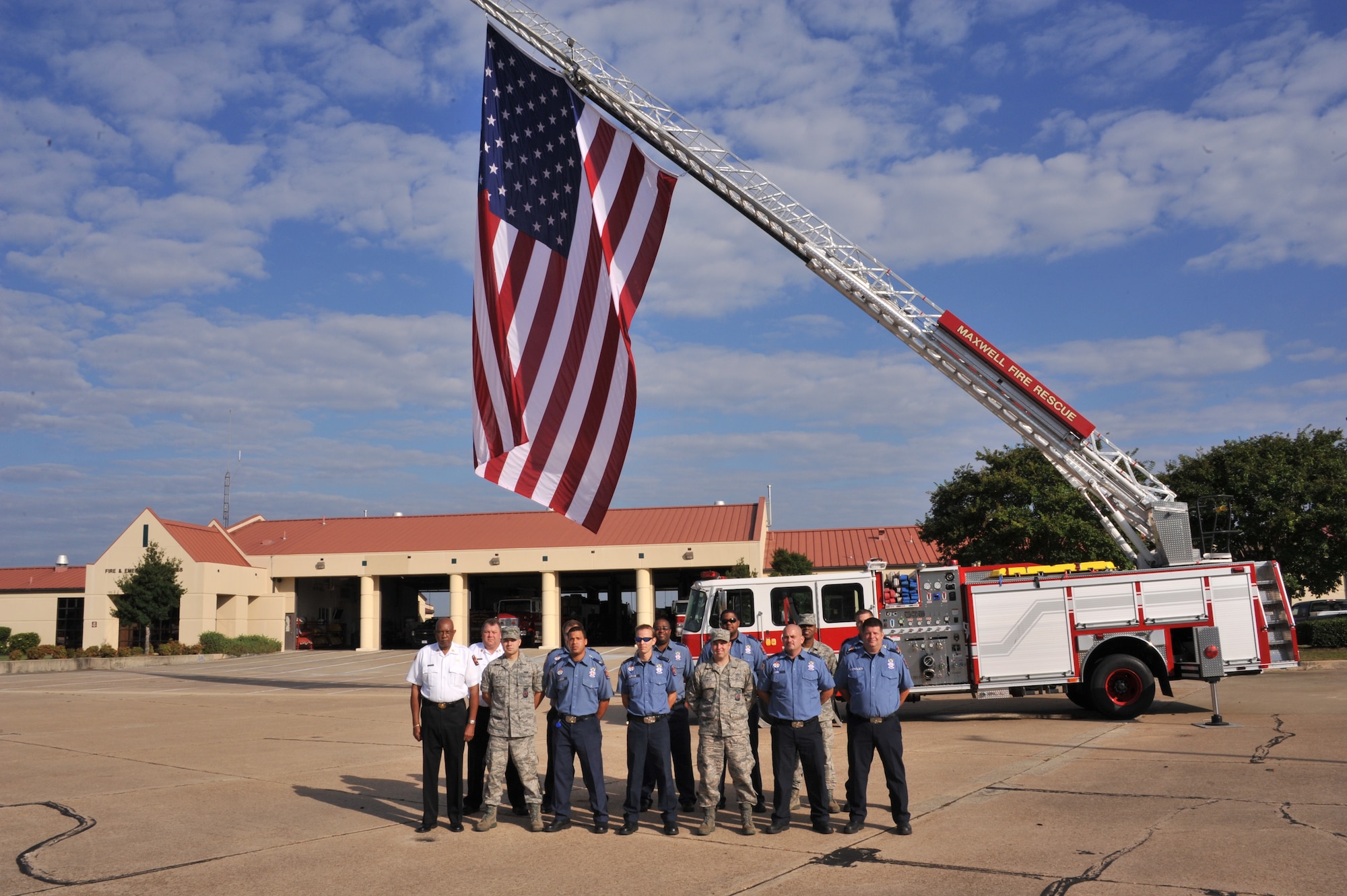 Firefighters from Maxwell Air Force Base pose for a photo in front of the American flag, Sept. 11. Maxwell's fire department flies the flag at half- staff, honoring those who lost their lives 11 years ago in New York City. (U.S. Air Force photo by Airman 1st Class William Blankenship) 