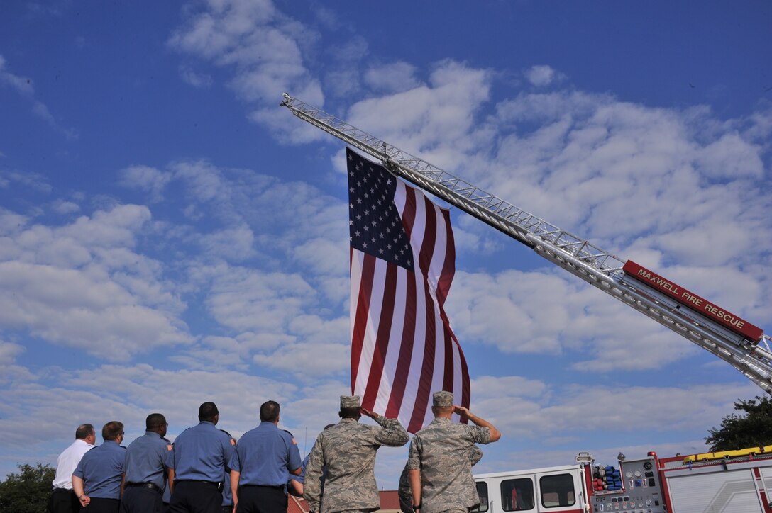 Member of the Maxwell Air Force Base Fire Department remember those who died 11 years ago in the  Sept. 11, 2001 tragedy as they fly the American flag at half- staff, Sept. 11. Both civilian and military firefighters paused their day to hold a moment of silence and a prayer on the anniversary of the attack on America.  (U.S. Air Force photo by Airman 1st Class William Blankenship)