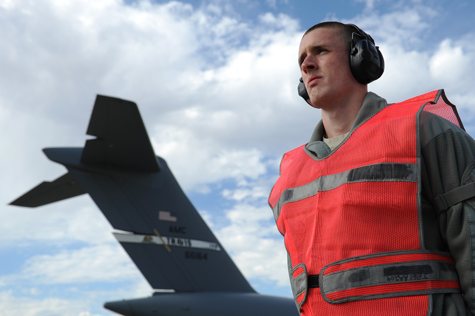 Senior Airman Luis Puerta, 571st Global Mobility Squadron, waits to marshal out a departing C-5 Galaxy during Exercise Gladiator Challenge. The exercise scenario included the CRW providing a contingency response team to respond to a simulated devastating earthquake in the San Francisco Bay area, which displaced 750, 000 simulated people. (U.S. Air Force Photo/MSgt Stan Parker)