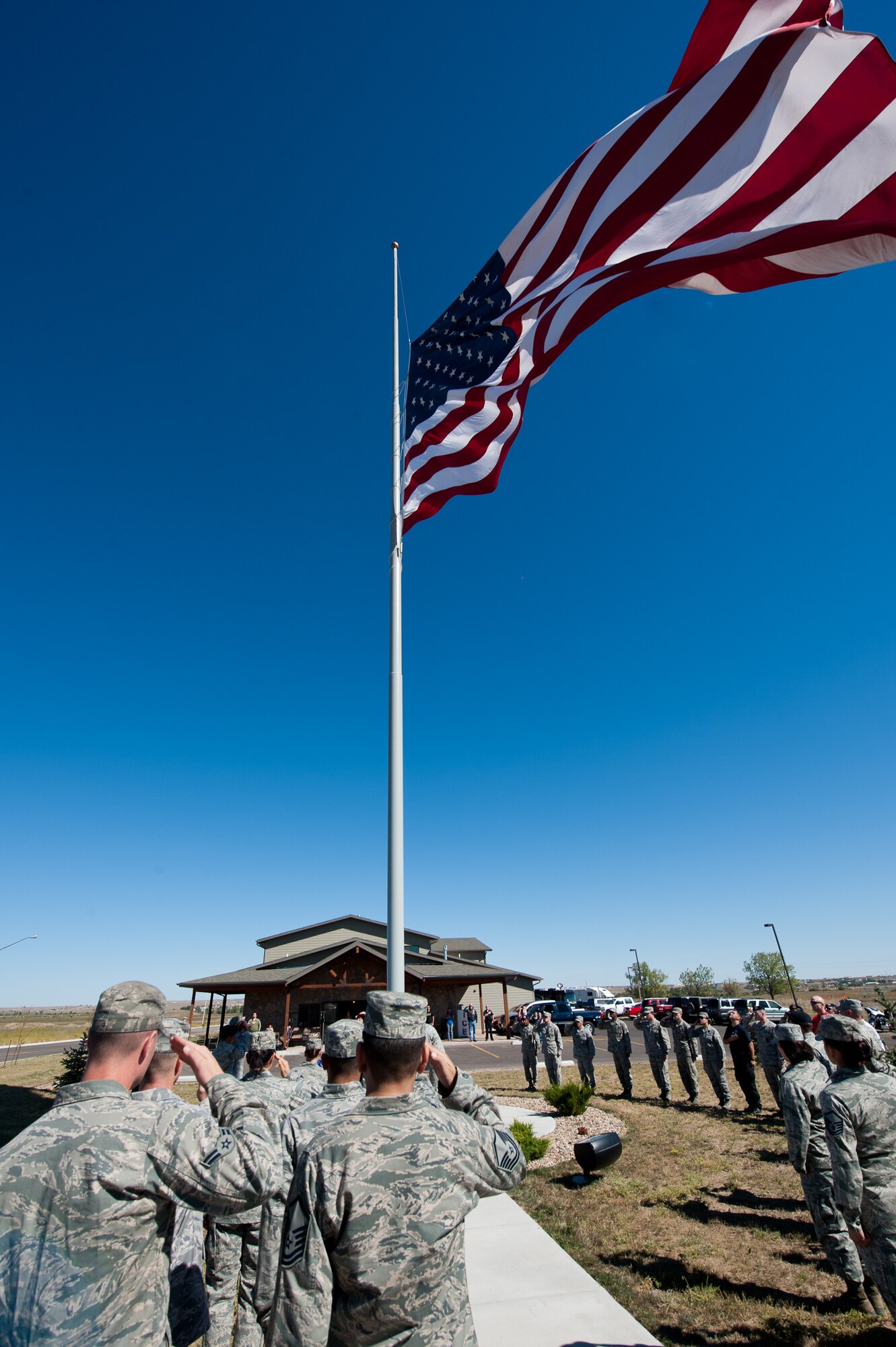 Airmen salute an American flag during a flag raising ceremony as part of a 9/11 Remembrance Ruck March on Ellsworth Air Force Base, S.D., Sept. 8, 2012. Airmen, families and first responders from surrounding communities gathered to recognize and honor the nearly 3,000 of lives lost 11 years ago on Sept. 11. (U.S. Air Force photo by Airman 1st Class Kate Thornton-Maurer)