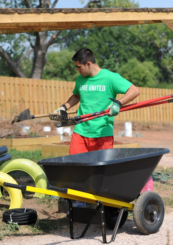 Tech. Sgt. Brett Guzman, 28th Bomb Wing Command Post NCO in charge of console operations, arranges landscaping tools in a garden plot at the South Dakota Game, Fish and Parks Outdoor Campus West in Rapid City, S.D., during the United Way of the Black Hills Day of Caring Sept. 6, 2012. The Day of Caring was established in 1992 to promote the spirit and value of volunteerism, increase the awareness of local human service agencies and schools, and demonstrate what people working together for the community's good can accomplish. (U.S. Air Force photo by Airman 1st Class Hrair H. Palyan/Released)