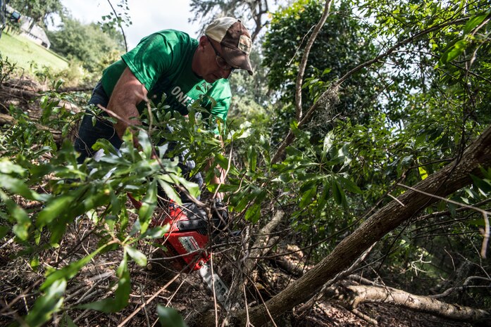 Master Sgt. Kevin Lemere, 437th Maintenance Squadron Test Measurement and Diagnostic Equipment (TMDE) flight chief, uses a chainsaw to remove bushes by a nearby lake at the Girl Scout Plantation on Sept. 7, 2012 in Cordesville, S.C.  Various units of JB Charleston participated in aiding restoration of the facilities on the camp.  The Day of Caring, organized locally by the Trident United Way, saw more than 8,500 volunteers working on more than 300 projects around the Lowcountry.