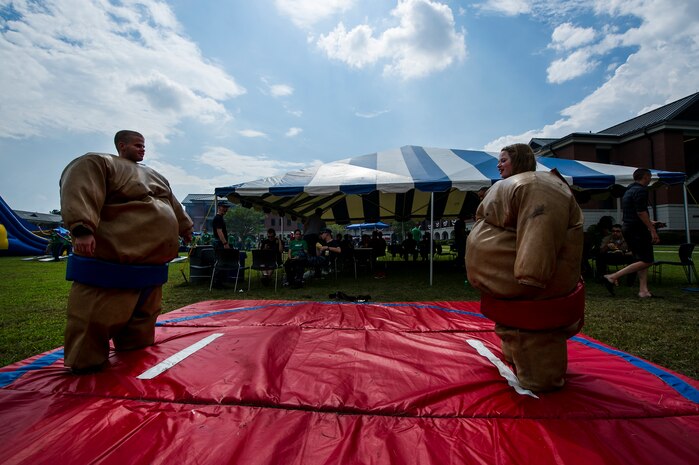 Seaman Joseph Standifer and Seaman Alycia Huntington, Naval Nuclear Power Training Command Electrician’s Mate students, prepare to Sumo wrestle during the "Barracks Bash" celebration after the Day of Caring Sept. 7, 2012, at Joint Base Charleston - Weapons Station, S.C. The Day of Caring, organized locally by the Trident United Way, saw more than 8,500 volunteers working on more than 300 projects around the Lowcountry. (U.S. Air Force photo/Airman 1st Class George Goslin)