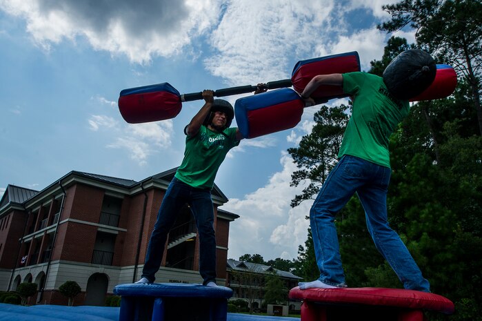 Seaman Dixon Andrew and Seaman Alex Harbeson, Naval Nuclear Power Training Command Electrician’s Mate students, fight with pugil sticks during the "Barracks Bash" celebration after the Day of Caring Sept. 7, 2012, at Joint Base Charleston - Weapons Station, S.C. The Day of Caring, organized locally by the Trident United Way, saw more than 8,500 volunteers working on more than 300 projects around the Lowcountry. (U.S. Air Force photo by Airman 1st Class George Goslin)