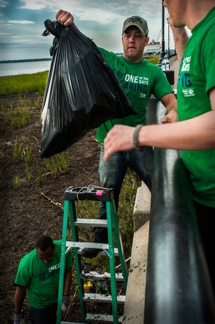 Senior Airman Michael Joiner, 628th Security Forces Squadron, hands a bag of trash to Airman 1st Class Eric Weitzel, 628th Security Forces Squadron, Sept. 7, 2012, at the Waterfront Park in downtown Charleston, S.C. The Waterfront Park cleanup was coordinated with the help of “Keep Charleston Beautiful,” a non-profit organization dedicated to promoting the cleanliness and beautification of the City of Charleston through education, public awareness and community involvement. The Day of Caring, organized locally by the Trident United Way, saw more than 8,500 volunteers working on more than 300 projects around the Lowcountry.
 (U.S. Air Force photo / Airman 1st Class Tom Brading)
