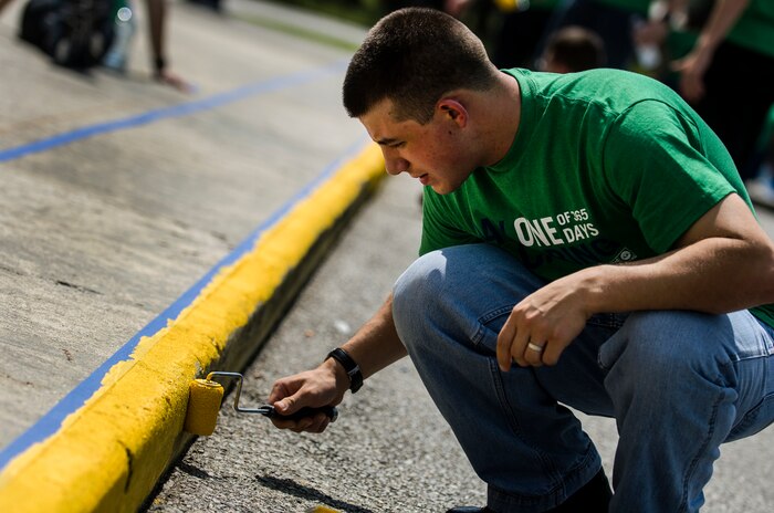Seaman Jarrod Fetty, Naval Nuclear Power Training Command Machinist’s Mate student, paints a curb at Marrington Elementary School during the Day of Caring Sept. 7, 2012, at Joint Base Charleston - Weapons Station, S.C. The Day of Caring, organized locally by the Trident United Way, saw more than 8,500 volunteers working on more than 300 projects around the Lowcountry. (U.S. Air Force photo/Airman 1st Class George Goslin)