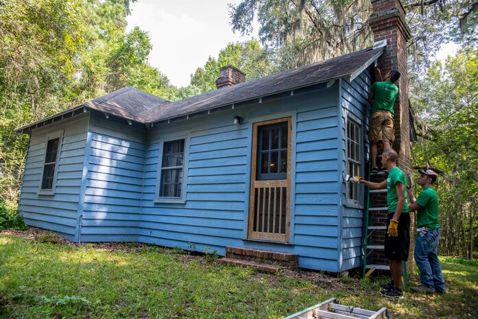 Members of Joint-Base Charleston-Air Base, S.C. paints a building at the Girl Scout Plantation on Sept. 7, 2012 in Cordesville, S.C.  Various units of JB Charleston participated in aiding restoration of the facilities on the camp.  The Day of Caring, organized locally by the Trident United Way, saw more than 8,500 volunteers working on more than 300 projects around the Lowcountry.