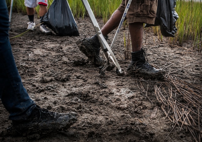The muddy bank of the Waterfront Park marsh can’t slow Joint Base Charleston – Air Base Airmen who volunteered during the “Day of Caring” event Sept. 7, 2012, in downtown Charleston, S.C. The Waterfront Park cleanup was coordinated with the help of “Keep Charleston Beautiful,” a non-profit organization dedicated to promoting the cleanliness and beautification of the City of Charleston through education, public awareness and community involvement. The Day of Caring, organized locally by the Trident United Way, saw more than 8,500 volunteers working on more than 300 projects around the Lowcountry.
 (U.S. Air Force photo / Airman 1st Class Tom Brading)
