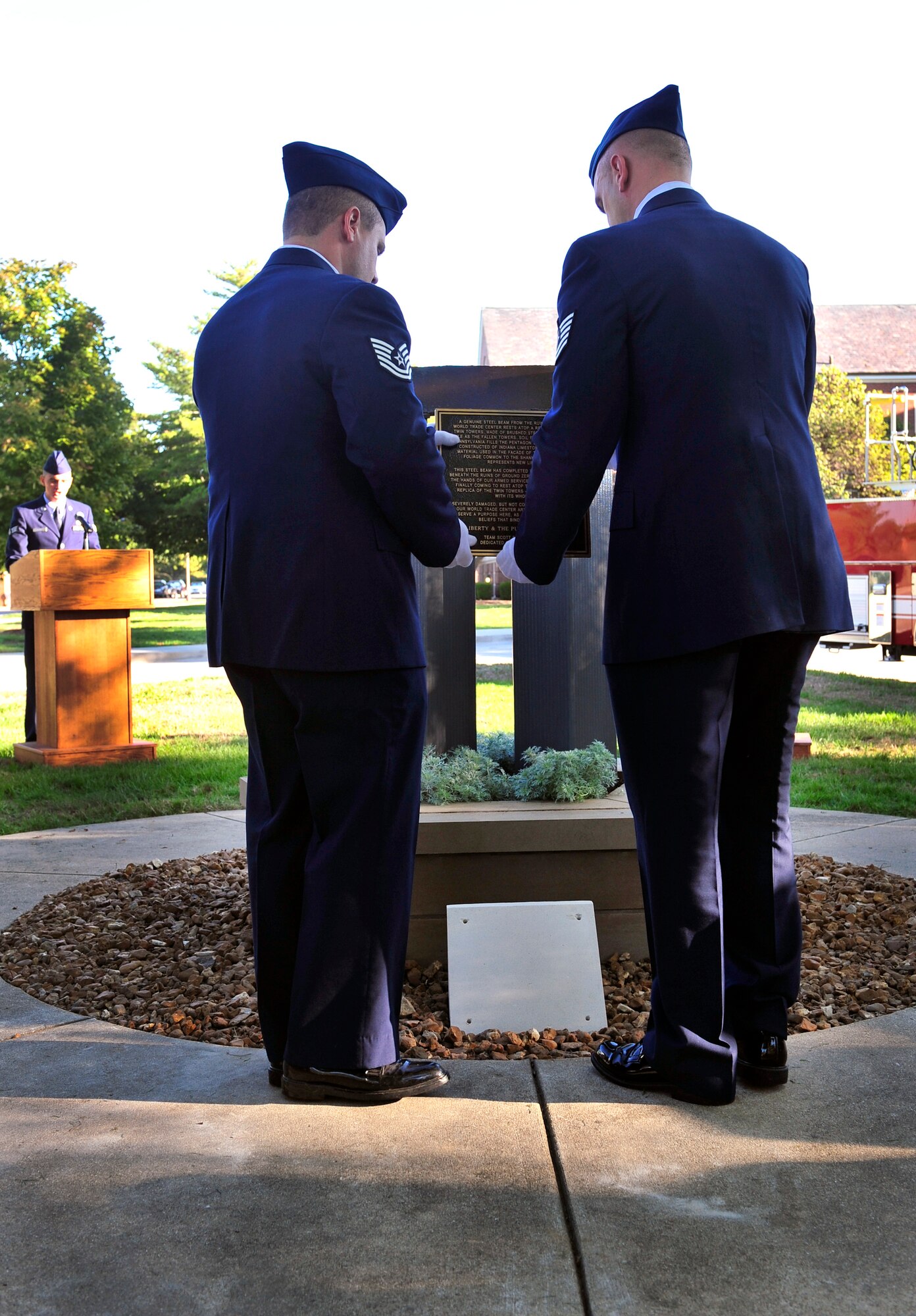Two U.S. Air Force members place a new plaque explaining what each piece on the Scott 9/11 memorial represents during the 2012 9/11 remembrance ceremony on Scott Air Force Base, Ill. (U.S. Air Force photos by Staff Sgt. Stephenie Wade)     
