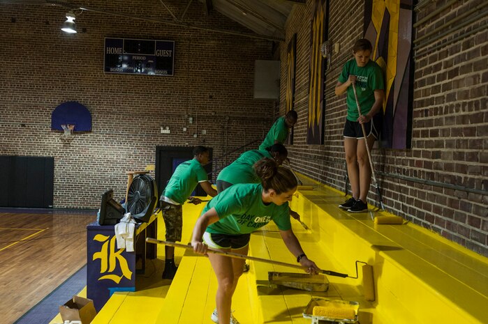 Airmen from Joint Base Charleston paint bleachers Sept. 7, 2012, at Rollings Middle School of the Arts in Summerville, S.C. The Day of Caring, organized locally by the Trident United Way, saw more than 8,500 volunteers working on more than 300 projects around the Lowcountry. (U.S. Air Force photo/Airman 1st Class Ashlee Galloway)