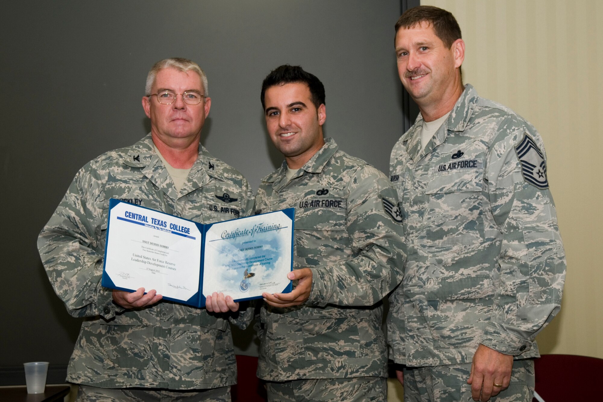 GRISSOM AIR RESERVE BASE, Ind. -- Staff Sgt. Dennis Sommo, 434th Maintenance Operations Flight information management specialist, receives a certificate of training from Col. Don Buckley, 434th Air Refueling Wing commander, and Chief Master Sergeant James Burba, 434th MOF maintenance superintendent, at a graduation ceremony for a Non-Commissioned Officer Leadership Development Course here Aug. 17. Sommo graduated the course with 20 other NCOs. (U.S. Air Force photo/Senior Airman Andrew McLaughlin)