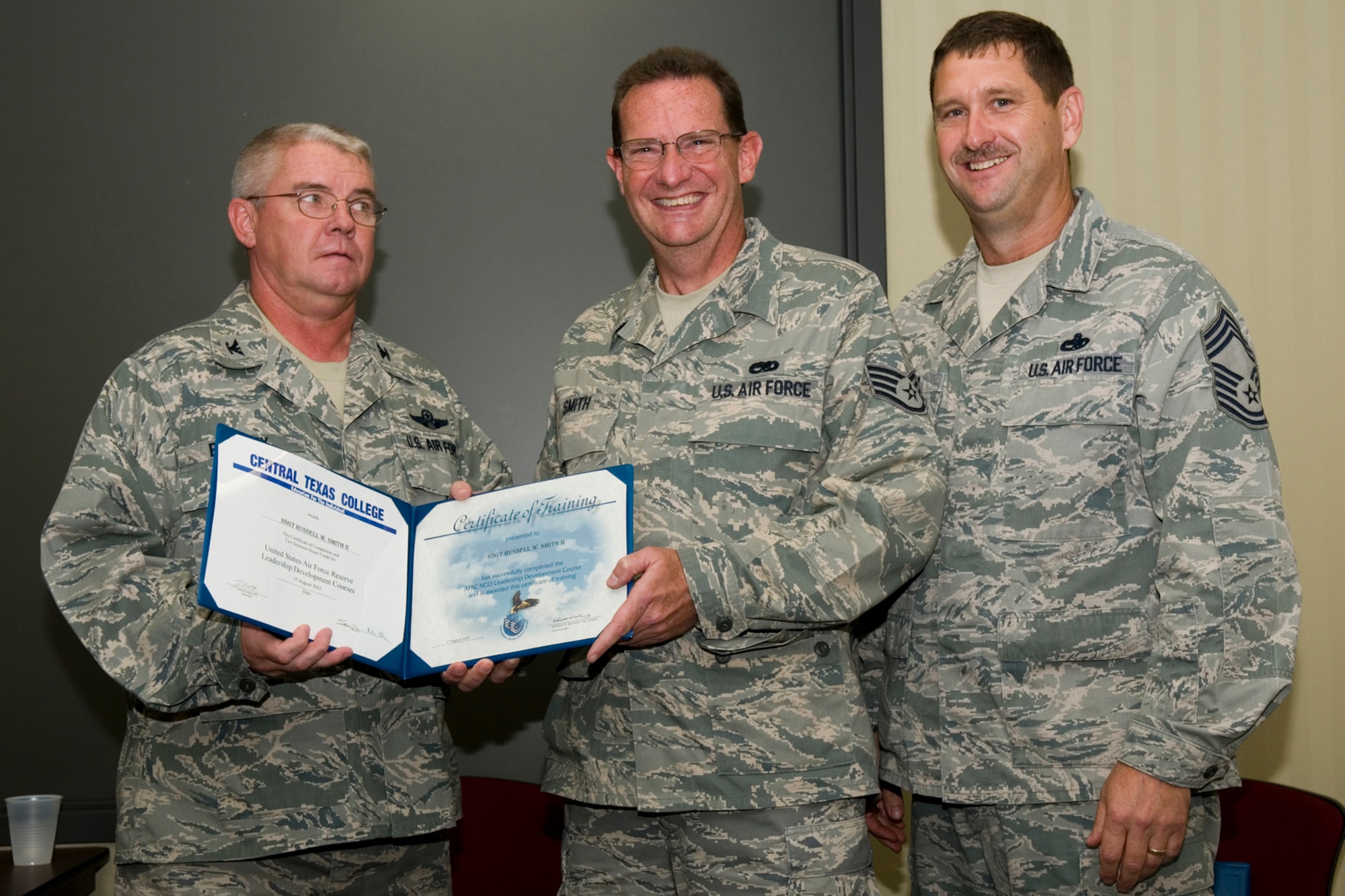 GRISSOM AIR RESERVE BASE, Ind. -- Staff Sgt. Russell Smith, 434th Aircraft Maintenance Squadron integrated avionics systems apprentice, receives a certificate of training from Col. Don Buckley, 434th Air Refueling Wing commander, and Chief Master Sergeant James Burba, 434th Maintenance Operations Flight maintenance superintendent, at a graduation ceremony for a Non-Commissioned Officer Leadership Development Course here Aug. 17. Smith graduated the course with 20 other NCOs. (U.S. Air Force photo/Senior Airman Andrew McLaughlin)