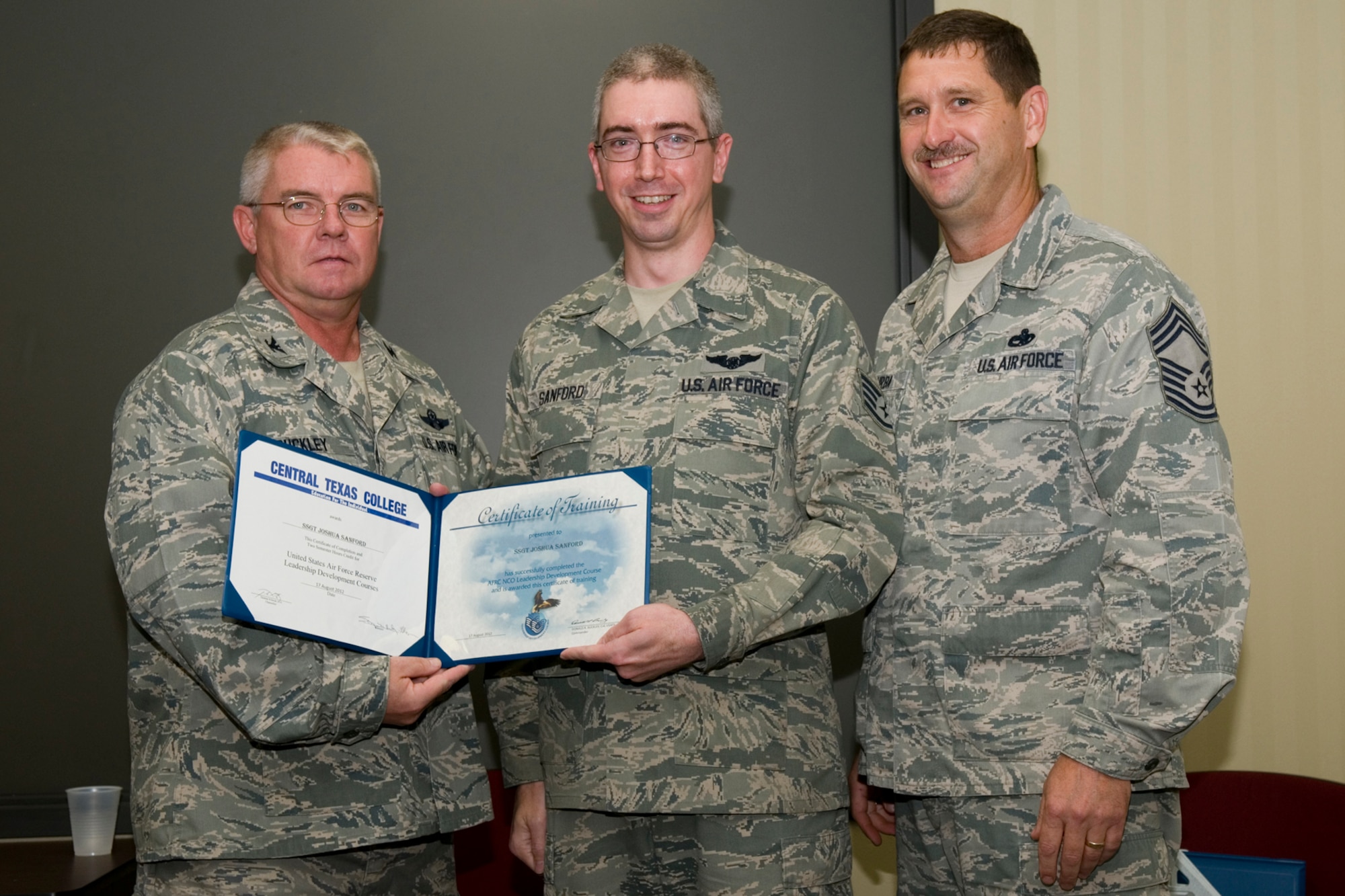 GRISSOM AIR RESERVE BASE, Ind. -- Staff Sgt. Joshua Sanford, 72nd Air Refueling Squadron in-flight refueling technician, receives a certificate of training from Col. Don Buckley, 434th Air Refueling Wing commander, and Chief Master Sergeant James Burba, 434th Maintenance Operations Flight maintenance superintendent, at a graduation ceremony for a Non-Commissioned Officer Leadership Development Course here Aug. 17. Sanford graduated the course with 20 other NCOs. (U.S. Air Force photo/Senior Airman Andrew McLaughlin)
