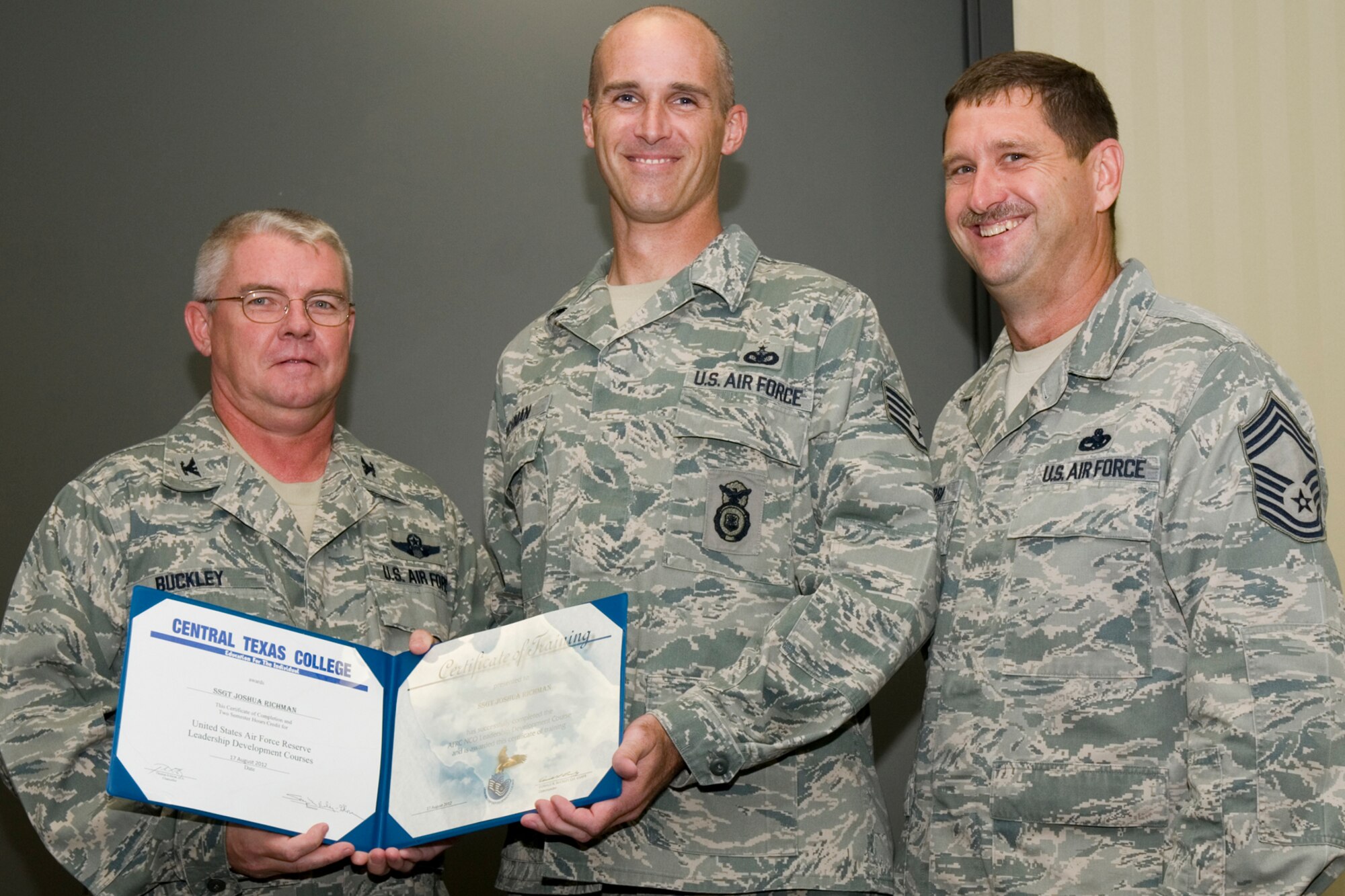 GRISSOM AIR RESERVE BASE, Ind. -- Staff Sgt. Joshua Richman, 434th Security Forces Squadron security response team member, receives a certificate of training from Col. Don Buckley, 434th Air Refueling Wing commander, and Chief Master Sergeant James Burba, 434th Maintenance Operations Flight maintenance superintendent, at a graduation ceremony for a Non-Commissioned Officer Leadership Development Course here Aug. 17. Richman graduated the course with 20 other NCOs. (U.S. Air Force photo/Senior Airman Andrew McLaughlin)