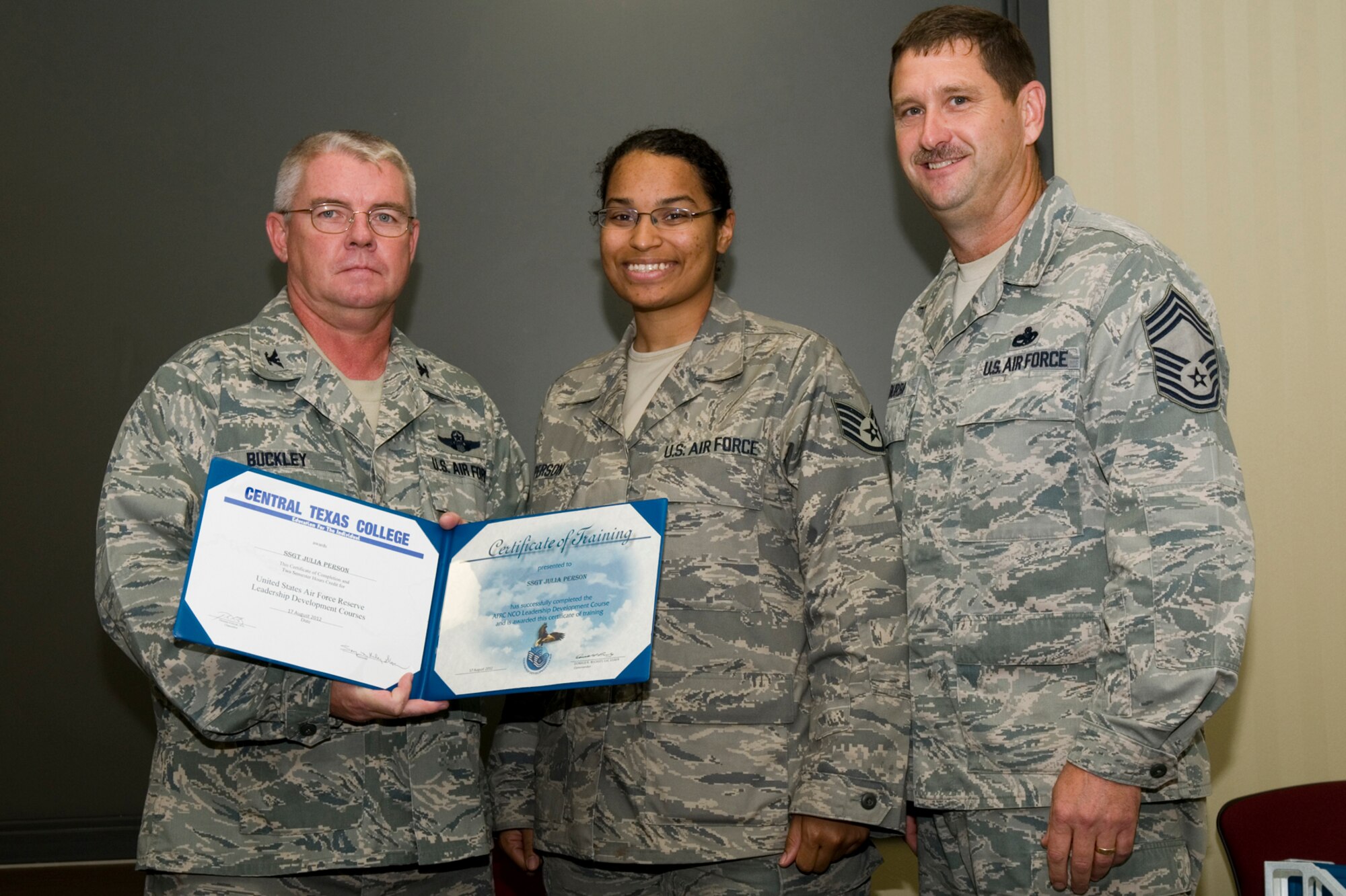GRISSOM AIR RESERVE BASE, Ind. -- Staff Sgt. Julia Person, 434th Aircraft Maintenance Squadron KC-135 crew chief, receives a certificate of training from Col. Don Buckley, 434th Air Refueling Wing commander, and Chief Master Sergeant James Burba, 434th Maintenance Operations Flight maintenance superintendent, at a graduation ceremony for a Non-Commissioned Officer Leadership Development Course here Aug. 17. Person graduated the course with 20 other NCOs. (U.S. Air Force photo/Senior Airman Andrew McLaughlin)