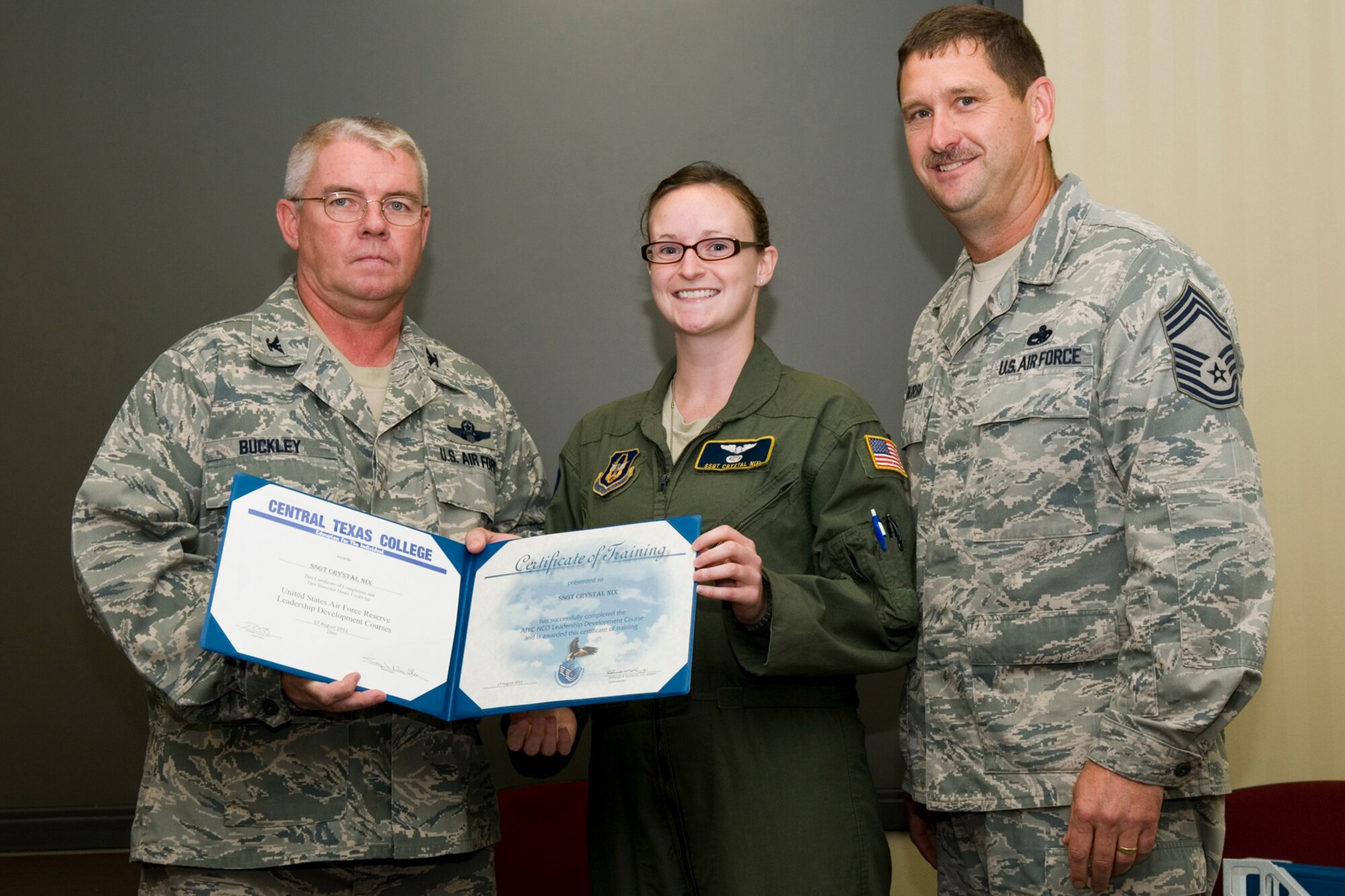 GRISSOM AIR RESERVE BASE, Ind. -- Staff Sgt. Crystal Nix, 72nd Air Refueling Squadron in-flight refueling technician, receives a certificate of training from Col. Don Buckley, 434th Air Refueling Wing commander, and Chief Master Sergeant James Burba, 434th Maintenance Operations Flight maintenance superintendent, at a graduation ceremony for a Non-Commissioned Officer Leadership Development Course here Aug. 17. Nix graduated the course with 20 other NCOs. (U.S. Air Force photo/Senior Airman Andrew McLaughlin)