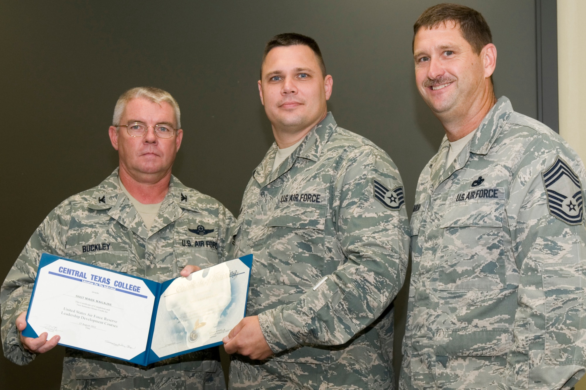 GRISSOM AIR RESERVE BASE, Ind. -- Staff Sgt. Mark Magajne, 49th Aerial Port Flight aerial port apprentice, receives a certificate of training from Col. Don Buckley, 434th Air Refueling Wing commander, and Chief Master Sergeant James Burba, 434th Maintenance Operations Flight maintenance superintendent, at a graduation ceremony for a Non-Commissioned Officer Leadership Development Course here Aug. 17. Magajne graduated the course with 20 other NCOs. (U.S. Air Force photo/Senior Airman Andrew McLaughlin)