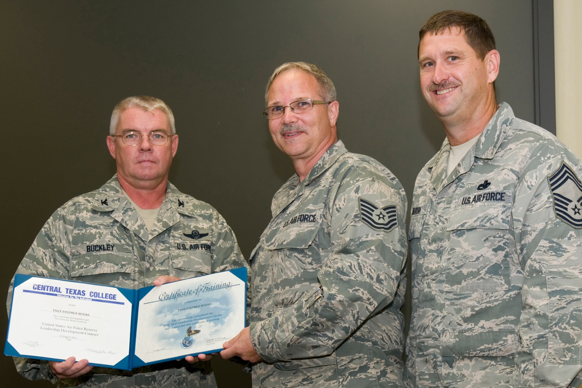 GRISSOM AIR RESERVE BASE, Ind. -- Tech. Sgt. Stephen Hudak, 434th Civil Engineer Squadron HVAC and refridgeration journeyman, receives a certificate of training from Col. Don Buckley, 434th Air Refueling Wing commander, and Chief Master Sergeant James Burba, 434th Maintenance Operations Flight maintenance superintendent, at a graduation ceremony for a Non-Commissioned Officer Leadership Development Course here Aug. 17. Hudak graduated the course with 20 other NCOs. (U.S. Air Force photo/Senior Airman Andrew McLaughlin)