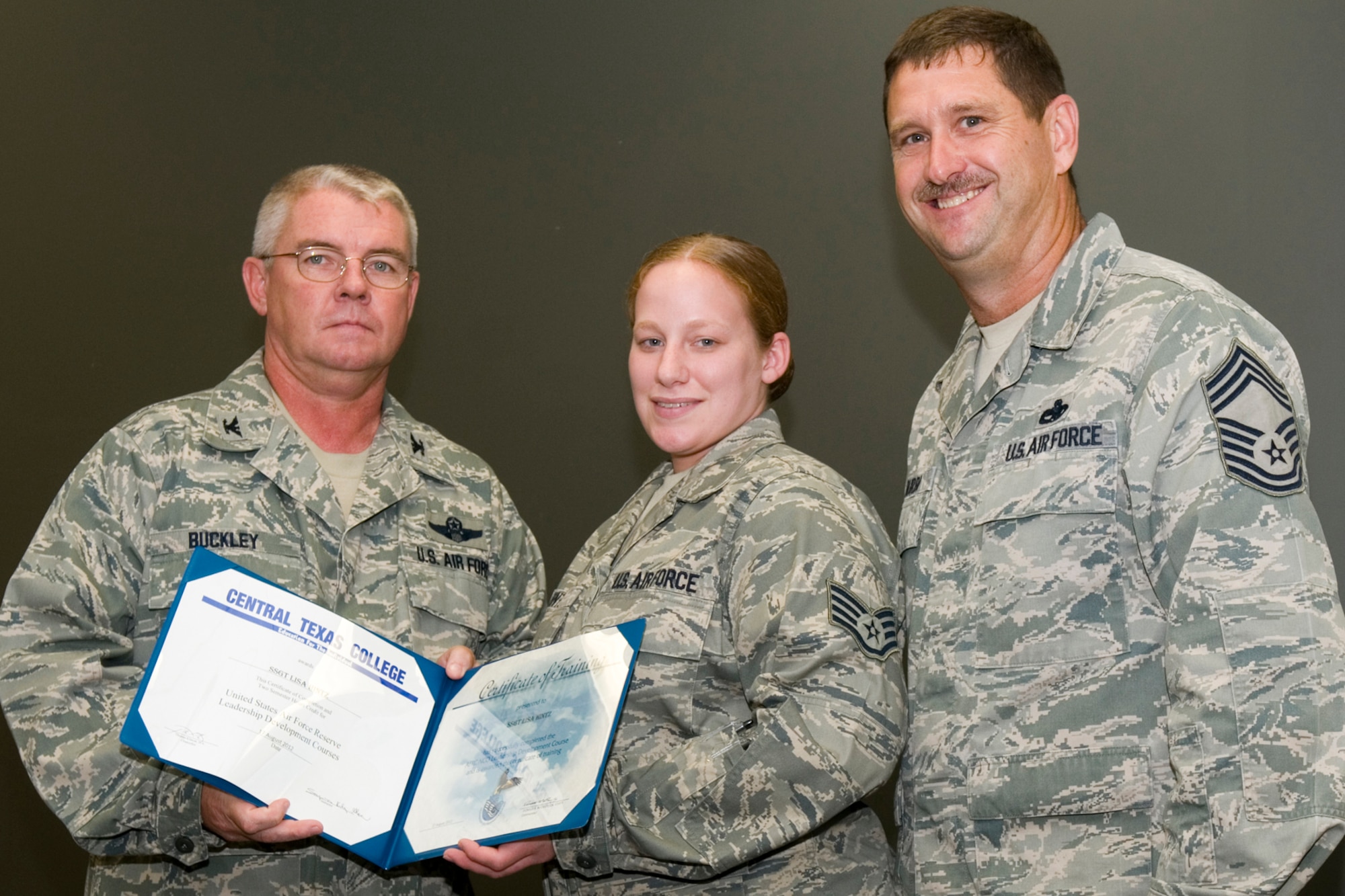 GRISSOM AIR RESERVE BASE, Ind. -- Staff Sgt. Lisa Hintz, 434th Logistics Readiness Squadron supply management journeyman, receives a certificate of training from Col. Don Buckley, 434th Air Refueling Wing commander, and Chief Master Sergeant James Burba, 434th Maintenance Operations Flight maintenance superintendent, at a graduation ceremony for a Non-Commissioned Officer Leadership Development Course here Aug. 17. Hintz graduated the course with 20 other NCOs. (U.S. Air Force photo/Senior Airman Andrew McLaughlin)