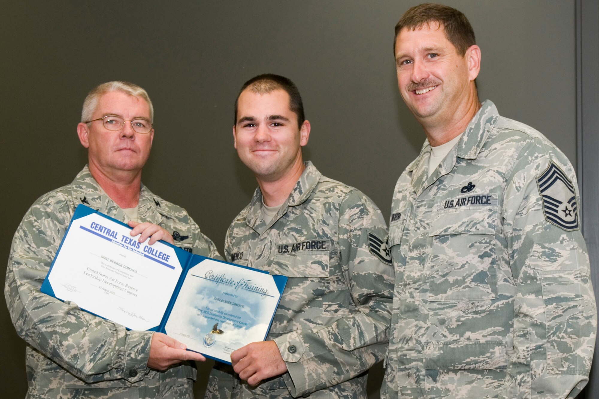 GRISSOM AIR RESERVE BASE, Ind. -- Staff Sgt. Derrek Dimenco, 434th Aircraft Maintenance Squadron KC-135 crew chief, receives a certificate of training from Col. Don Buckley, 434th Air Refueling Wing commander, and Chief Master Sergeant James Burba, 434th Maintenance Operations Flight maintenance superintendent, at a graduation ceremony for a Non-Commissioned Officer Leadership Development Course here Aug. 17. Dimenco graduated the course with 20 other NCOs. (U.S. Air Force photo/Senior Airman Andrew McLaughlin)