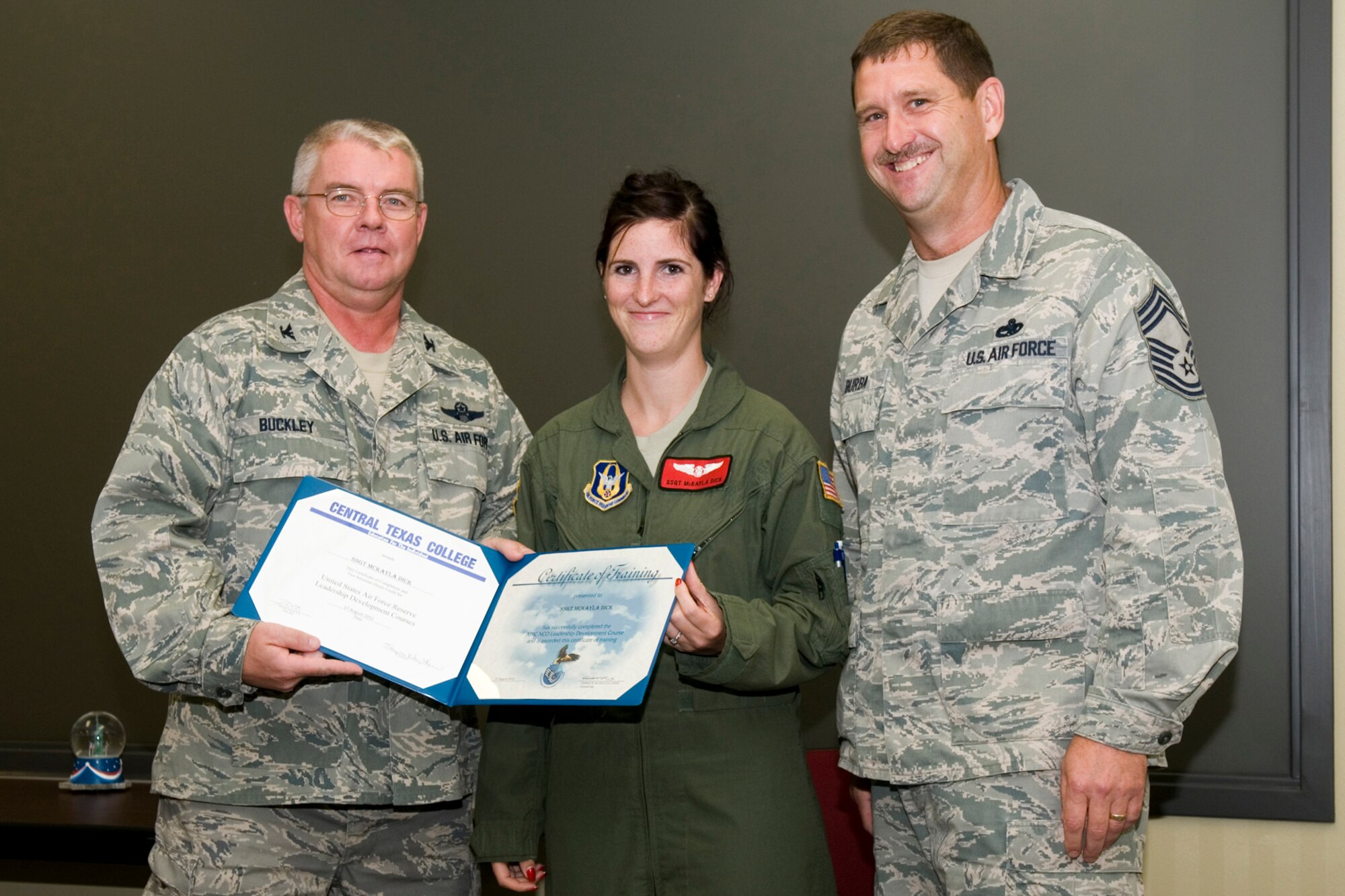 GRISSOM AIR RESERVE BASE, Ind. -- Staff Sgt. McKayla Dick, 74th Air Refueling Squadron inflight refueling technician, receives a certificate of training from Col. Don Buckley, 434th Air Refueling Wing commander, and Chief Master Sergeant James Burba, 434th Maintenance Operations Flight maintenance superintendent, at a graduation ceremony for a Non-Commissioned Officer Leadership Development Course here Aug. 17. Dick graduated the course with 20 other NCOs. (U.S. Air Force photo/Senior Airman Andrew McLaughlin)