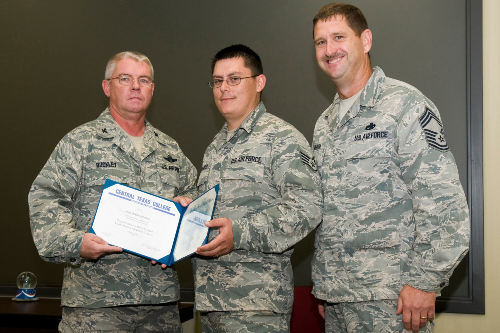 GRISSOM AIR RESERVE BASE, Ind. -- Staff Sgt. Shawn Colaizzi, 434th Civil Engineer Squadron pavement and construction apprentice, receives a certificate of training from Col. Don Buckley, 434th Air Refueling Wing commander, and Chief Master Sergeant James Burba, 434th Maintenance Operations Flight maintenance superintendent, at a graduation ceremony for a Non-Commissioned Officer  Leadership Development Course here Aug. 17. Colaizzi graduated the course with 20 other NCOs. (U.S. Air Force photo/Senior Airman Andrew McLaughlin)