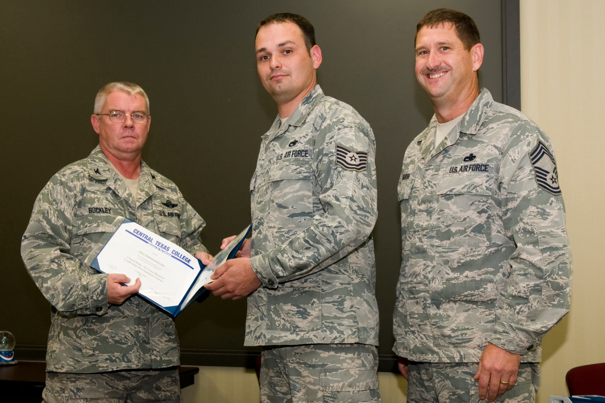 GRISSOM AIR RESERVE BASE, Ind. -- Tech. Sgt. Joseph Boelcke, 434th Aircraft Maintenance Squadron jet engine mechanic, receives a certificate of training from Col. Don Buckley, 434th Air Refueling Wing commander, and Chief Master Sergeant James Burba, 434th Maintenance Operations Flight maintenance superintendent, at a graduation ceremony for a Non-Commissioned Officer  Leadership Development Course here Aug. 17. Boelcke graduated the course with 20 other NCOs. (U.S. Air Force photo/Senior Airman Andrew McLaughlin)