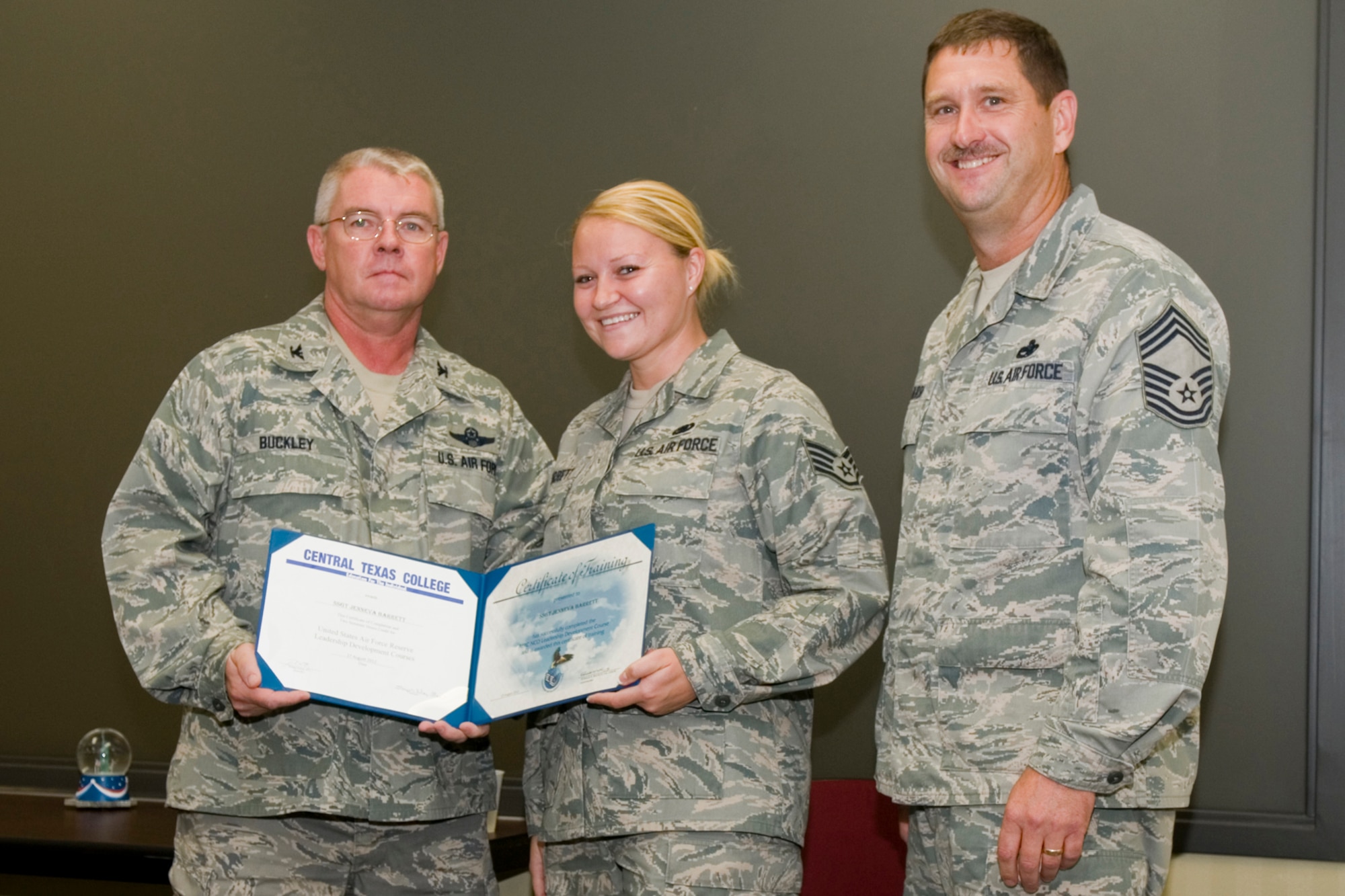 GRISSOM AIR RESERVE BASE, Ind. -- Staff Sgt. Jenneva Barrett, 434th Logistics Readiness Squadron fuels supply technician, receives a certificate of training from Col. Don Buckley, 434th Air Refueling Wing commander, and Chief Master Sergeant James Burba, 434th Maintenance Operations Flight maintenance superintendent, at a graduation ceremony for a Non-Commissioned Officer Leadership Development Course here Aug. 17. Barrett graduated the course with 20 other NCOs. (U.S. Air Force photo/Senior Airman Andrew McLaughlin)