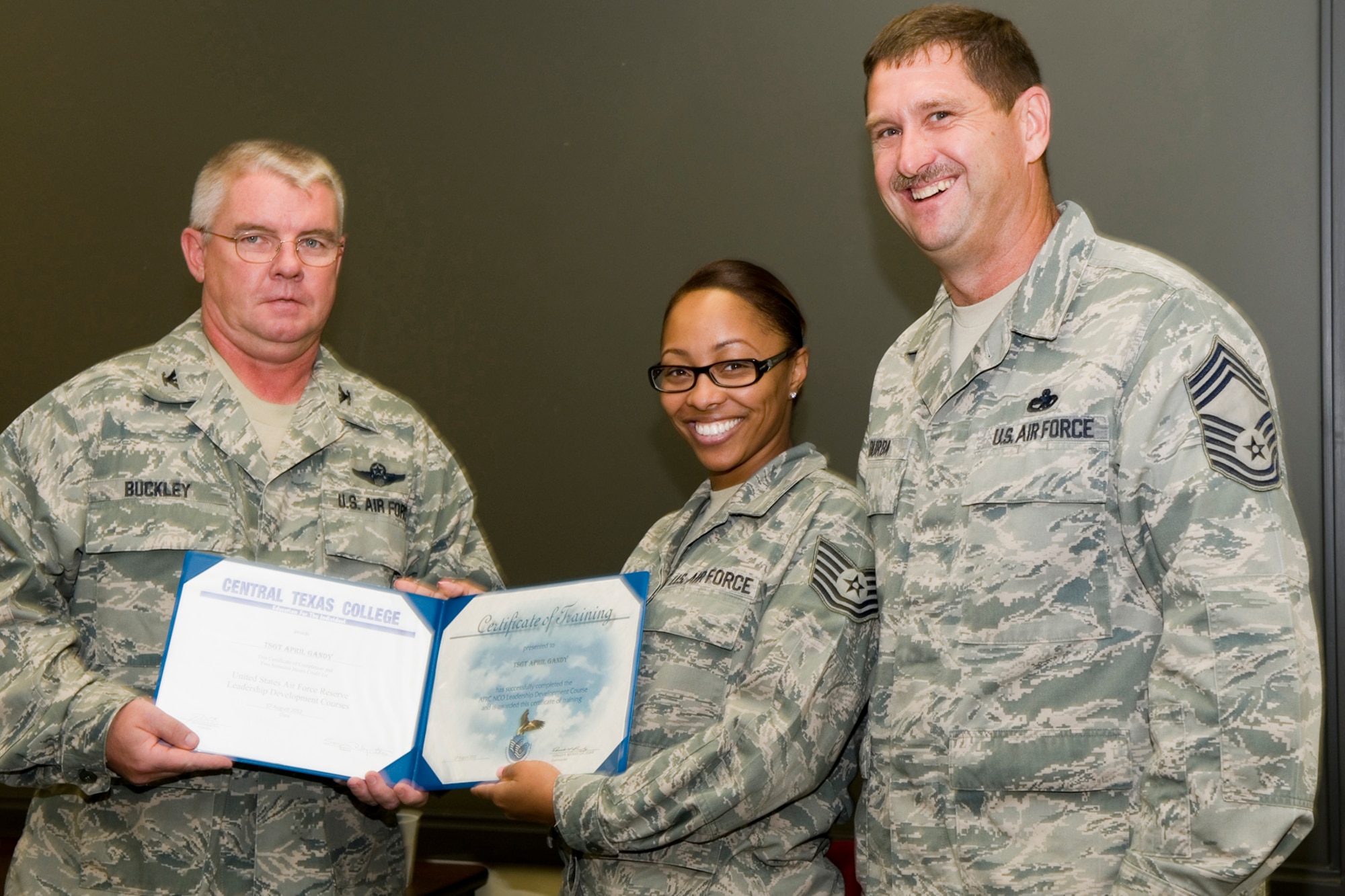 GRISSOM AIR RESERVE BASE, Ind. -- Tech. Sgt. April Gandy, 434th Force Support Squadron services specialist, receives a certificate of training from Col. Don Buckley, 434th Air Refueling Wing commander, and Chief Master Sergeant James Burba, 434th Maintenance Operations Flight maintenance superintendent, at a graduation ceremony for a Non-Commissioned Officer Leadership Development Course here Aug. 17. Gandy graduated the course with 20 other NCOs. (U.S. Air Force photo/Senior Airman Andrew McLaughlin)