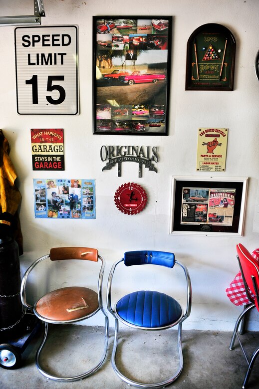Staff Sgt. Raul Chavez display of wall of fame located in his “man cave”. One of the items is a magazine featuring the first car he ever restored, a 1976 Monte Carlo, which I made into a functional convertible. He also restored the right chair using an old car interior kit and the metal signs using a sand blaster. (U.S. Air Force photo/ Staff Sgt. Stephenie Wade)