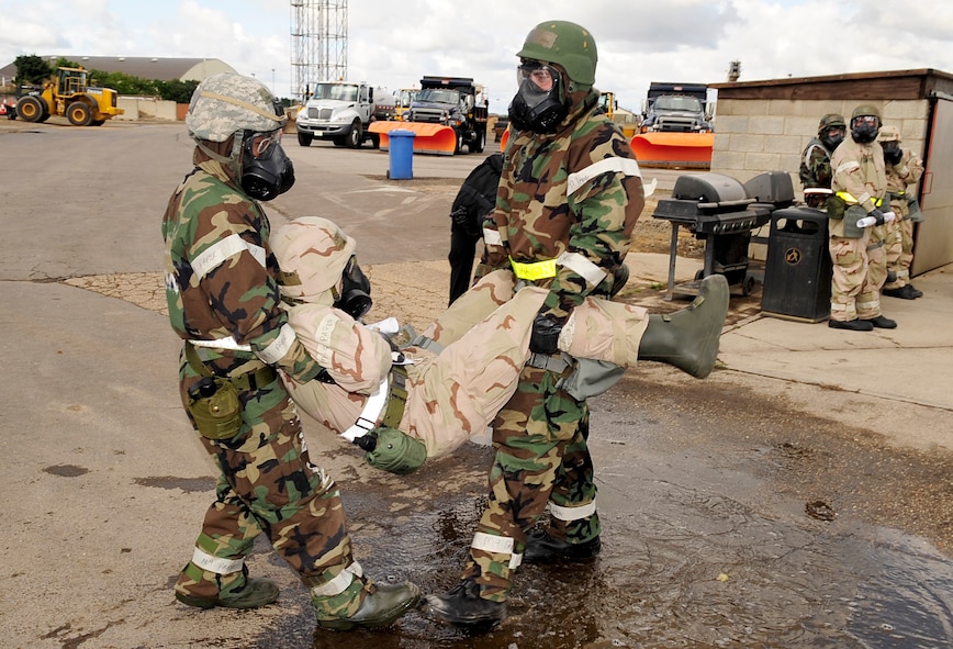 RAF MILDENHALL, England – Airmen from the 100th Civil Engineer Squadron carry a simulated injured comrade during an operational readiness exercise Sept. 11, 2012, at RAF Mildenhall. The Airmen received artificial injuries after being caught in a simulated unexploded ordnance explosion. (U.S. Air Force photo/Senior Airman Ethan Morgan)