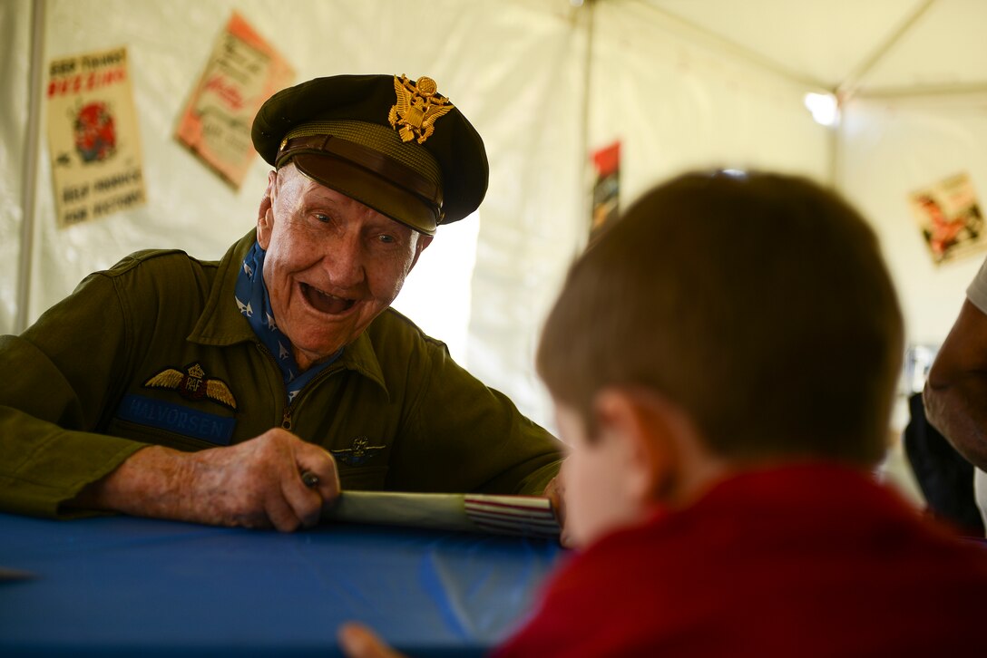 Col.(Ret.) Gail Halvorsen signs an autograph for Tucker Richard, 5, of Redfield, Ark. in the Heritage and Heroes tent at the Heritage and Heroes Open House and Airshow at Little Rock Air Force Base, Ark. on Sept. 8, 2012. Halvorsen was among a group of war veterans signing for the public. (U.S. Air Force photo by Staff Sgt. Russ Scalf)
