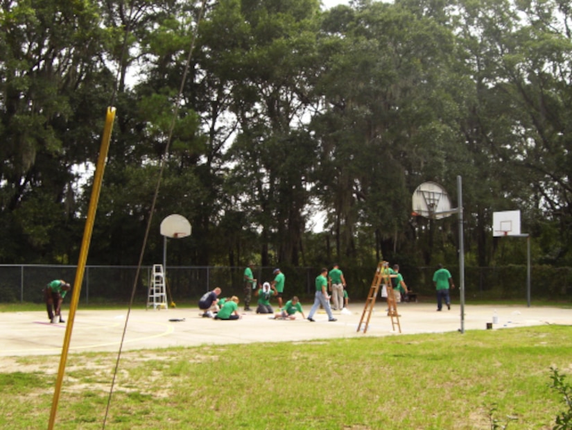 Chief petty officers and chief petty officer selects work together to tape and paint a basketball court Sept. 7, at Jane Edwards Elementary School, Edisto Island, S.C. The Day of Caring, organized locally by the Trident United Way, saw more than 8,500 volunteers working on more than 300 projects around the Lowcountry. (U.S. Navy photo/Chief Petty Officer Michael Vira)