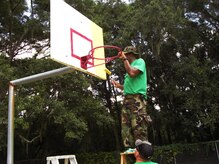 Hospital Corpsman Chief Petty Officer Select Walt Fuller paints a backboard Sept. 7, at the Jane Edwards Elementary School, Edisto Island, S.C. The Day of Caring, organized locally by the Trident United Way, saw more than 8,500 volunteers working on more than 300 projects around the Lowcountry. (U.S. Navy photo/Chief Petty Officer Michael Vira)