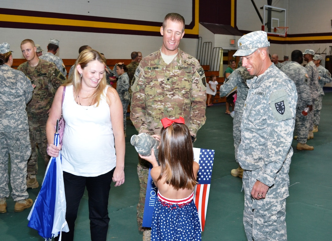 SPC Sean Coleman, center, assigned to the 119th Inland Cargo Transfer Company, 11th Transportation Battalion, 7th Sustainment Brigade, was welcomed home by his wife, daughter and Maj. Troy Temple, 11th Trans. Bn. executive officer after the 119th ICTC Redeployment Ceremony held atthe Forst Story gym, Sept. 6, 2012.  Capt. Richard Bragg, 119th ICTC Rear Detachment Commander, was the speaker for the event. (U.S. Army Courtesy Photo/Released)