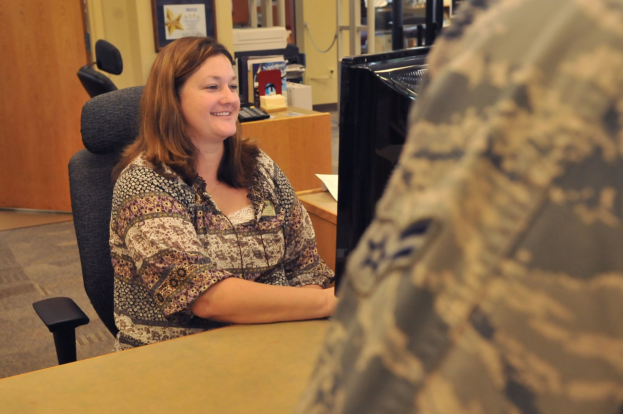 Cindy DeDeo, 20th Force Support Squadron, library technician circulations, talks to Airman about signing up for the use of library programs, Shaw Air Force Base, S.C., Sept.7, 2012. The McElveen library provides the technology as well as education essentials to aid Airmen in accomplishment the mission at Shaw.  (U.S. Air Force photo by Airman 1st Class Ashley L. Gardner/ Released)	
