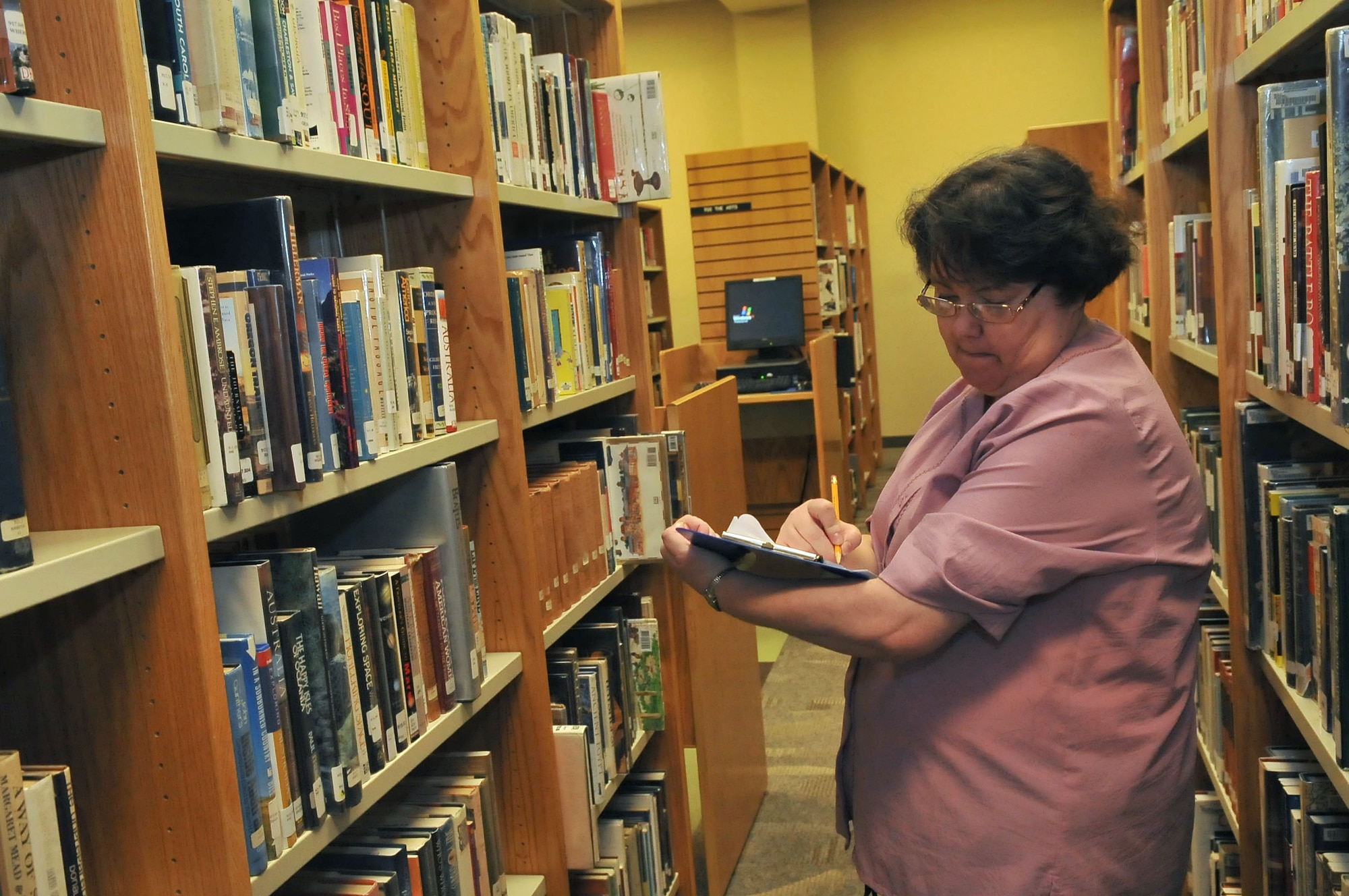Renee Thurmond, 20th Force Support Squadron library aide, takes inventory while on shift at the McElveen Library, Shaw Air Force Base, S.C., Sept.7, 2012. The library provides the technology as well as education essentials to aid Airmen in accomplishment the mission at Shaw. (U.S. Air Force photo by Airman 1st Class Ashley L. Gardner/ Released)
	
