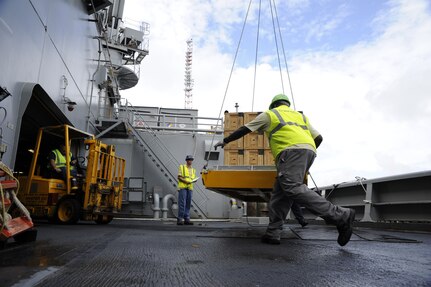 Dock worker move ammunition and supplies from Joint Base Charleston-Weapons Station to Military Sealift United States Navy Ship Lewis and Clark (T-AKE-1), Dry cargo/Ammunition Ship, during an ammunition onload recently at JB Charleston-Weapons Station.  More than 1700 pallets were received by USNS Ship Lewis and Clark during the onload.  It had been sixteen years since a ship has been pre-positioned at Joint Base Charleston-Weapons Station. (U.S. Air Force photo by Staff Sgt. Rasheen A. Douglas)