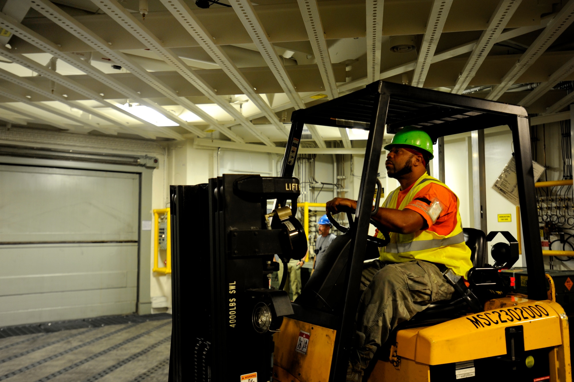 A dock worker move ammunition and supplies from Joint Base Charleston-Weapons Station to Military Sealift United States Navy Ship Lewis and Clark (T-AKE-1), Dry cargo/Ammunition Ship, during an ammunition onload recently at JB Charleston-Weapons Station.  More than 1700 pallets were received by USNS Ship Lewis and Clark during the onload.  It had been sixteen years since a ship has been pre-positioned at Joint Base Charleston-Weapons Station. (U.S. Air Force photo by Staff Sgt. Rasheen A. Douglas)
