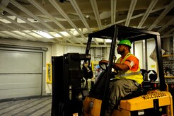 A dock worker positions a pallet of supplies onboard the USNS Lewis and Clark (T-AKE-1), during a recent ammunition onload recently at JB Charleston - Weapons Station, S.C.  More than 1,700 pallets were loaded onto the ship. This was the first onload of a Military Sealift Command pre-positioning  vessel at Joint Base Charleston - Weapons Station in 16 years. (U.S. Air Force photo/Staff Sgt. Rasheen  Douglas)