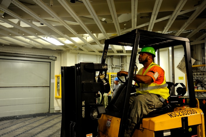 A dock worker move ammunition and supplies from Joint Base Charleston-Weapons Station to Military Sealift United States Navy Ship Lewis and Clark (T-AKE-1), Dry cargo/Ammunition Ship, during an ammunition onload recently at JB Charleston-Weapons Station.  More than 1700 pallets were received by USNS Ship Lewis and Clark during the onload.  It had been sixteen years since a ship has been pre-positioned at Joint Base Charleston-Weapons Station. (U.S. Air Force photo by Staff Sgt. Rasheen A. Douglas)