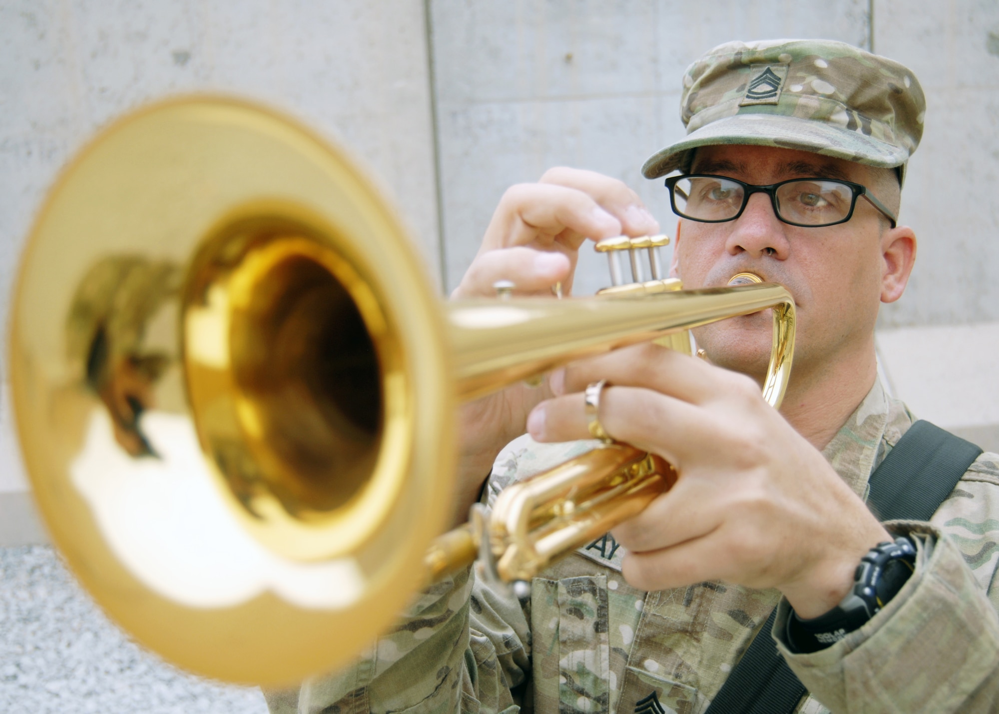U.S. Army Sgt. 1st Class Patrick Gray, 3rd Infantry Division bandsman, plays Taps as 451st Air Expeditionary Wing Honor Guardsmen lower the lower the flag to half-staff during a memorial ceremony here today. More than 200 U.S. and coalition forces joined together to observe the event. (U.S. Air Force photo/Master Sgt. Russell Martin)