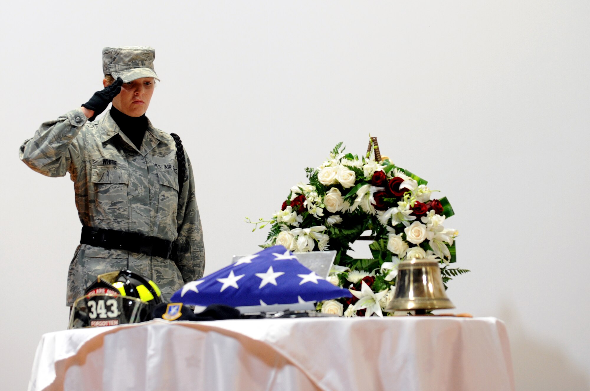 U.S. Air Force Airman 1st Class Kelsey White, 379th Expeditionary Civil Engineer Squadron,salutes the memorial table viewing during the 9/11 Commemoration Ceremony in Southwest Asia, September 11, 2012. The Grand Slam Wing observed the 11th anniversary of the Sept. 11, 2001 attack to honor and remember those who lost their lives at the World Trade Center, the Pentagon, the fields of Shanksville, Penn., and on the battlegrounds of Iraq and Afghanistan. (U.S. Air Force photo/Staff Sgt. Sheila deVera)