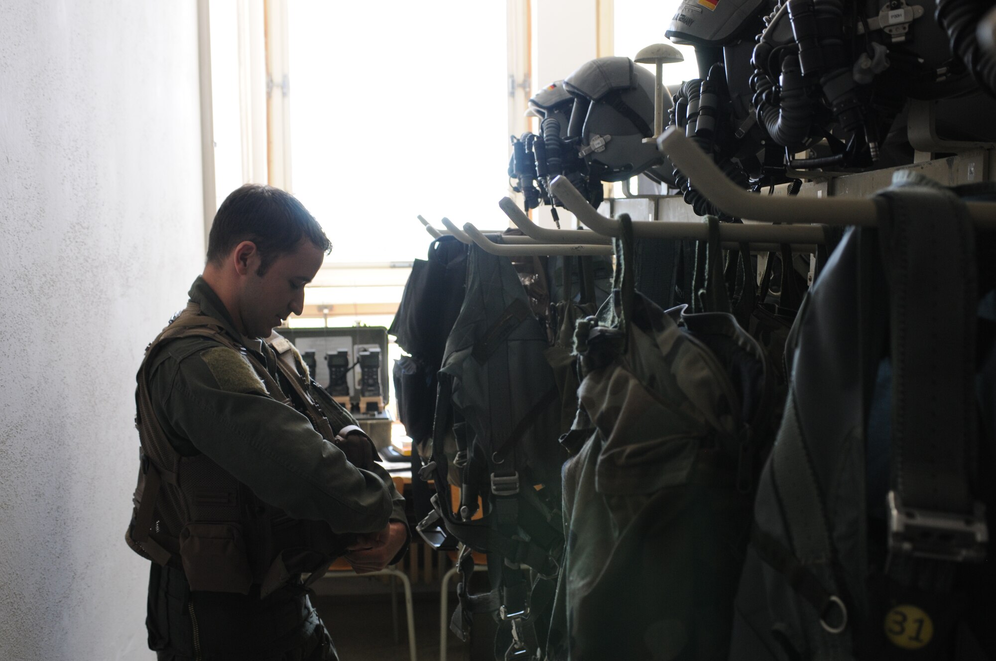 NAMEST AIR BASE, Czech Republic -- Capt. Bennet Merriman, 81st Fighter Squadron A-10 Thunderbolt II pilot, puts on his flight equipment before a close air support and forward air control training mission Sept. 10, during Ramstein Rover 2012 here. RARO 12 is a NATO partnership building exercise involving more than 16 nations. A-10 Thunderbolt IIs from the 81st FS are participating in the exercise to provide close air support to partnering nations and practice forward air control missions with their NATO allies in international security assistance force realistic scenarios. During this mission the 81st FS pilots supported German and Italian forward air controllers. Participating in exercises like RARO 12 ensures effective employment of airpower in support of alliance or coalition forces while mitigating risks to civilians in contingency operations. (U.S. Air Force photo by Senior Airman Natasha Stannard/Released)