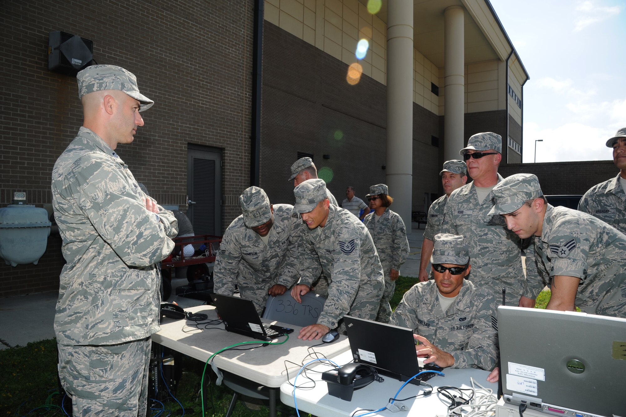 Lt. Col. Paul Griffin, 336th Training Squadron commander, gets acquainted with students in his squadron Sept. 6, 2012, as they set up air expeditionary force deployable training equipment used in the client systems course at Thompson Hall at Keesler Air Force Base, Miss.  (U.S. Air Force photo by Kemberly Groue)